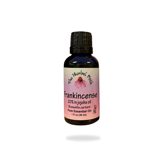 Bottle of Frankincense essential oil with a pink The Herbal Path label.