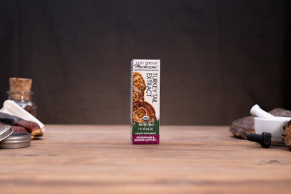 A box of Morchella Mushroom Extract powder stands centered on a wooden tabletop, with rustic props like a cork stopper, metal tin, and white mortar visible in the blurred background and foreground.