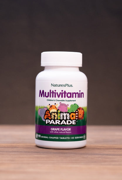 A bottle of Nature's Plus Multivitamin in Grain Flavor, set on a rustic wooden table with natural props like a cork stopper, dried herbs, and a mortar and pestle against a dark background.