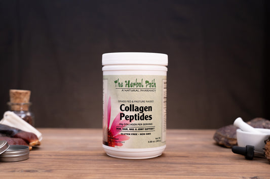 A white plastic bottle of Collagen Peptides by The Herbal Path, set on a rustic wooden table with herbal props like a mortar and pestle, crystals, and a small glass vial in the background against a dark backdrop.
