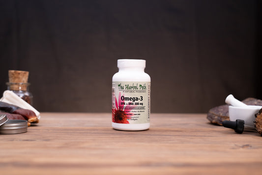 A white bottle of The Happy Peth Omega-3 DHA 200 mg supplement, set on a rustic wooden table with herbal props in the background.