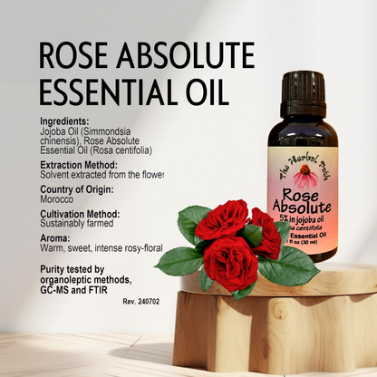 Rose Absolute essential oil bottle with red roses on a wooden block against a light background