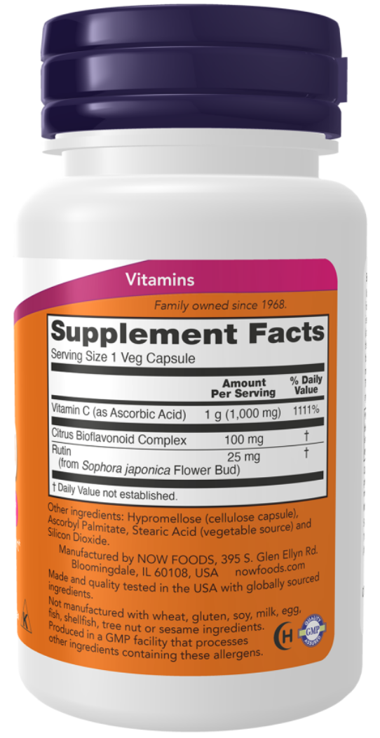 A white plastic bottle of vitamins with a dark purple cap and a prominent orange label showing supplement facts.