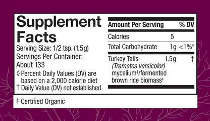 A close-up of a supplement facts label on a purple package background. The label is white with black text and shows serving size, calories, total carbohydrate, turkey tails, and certified organic information.
