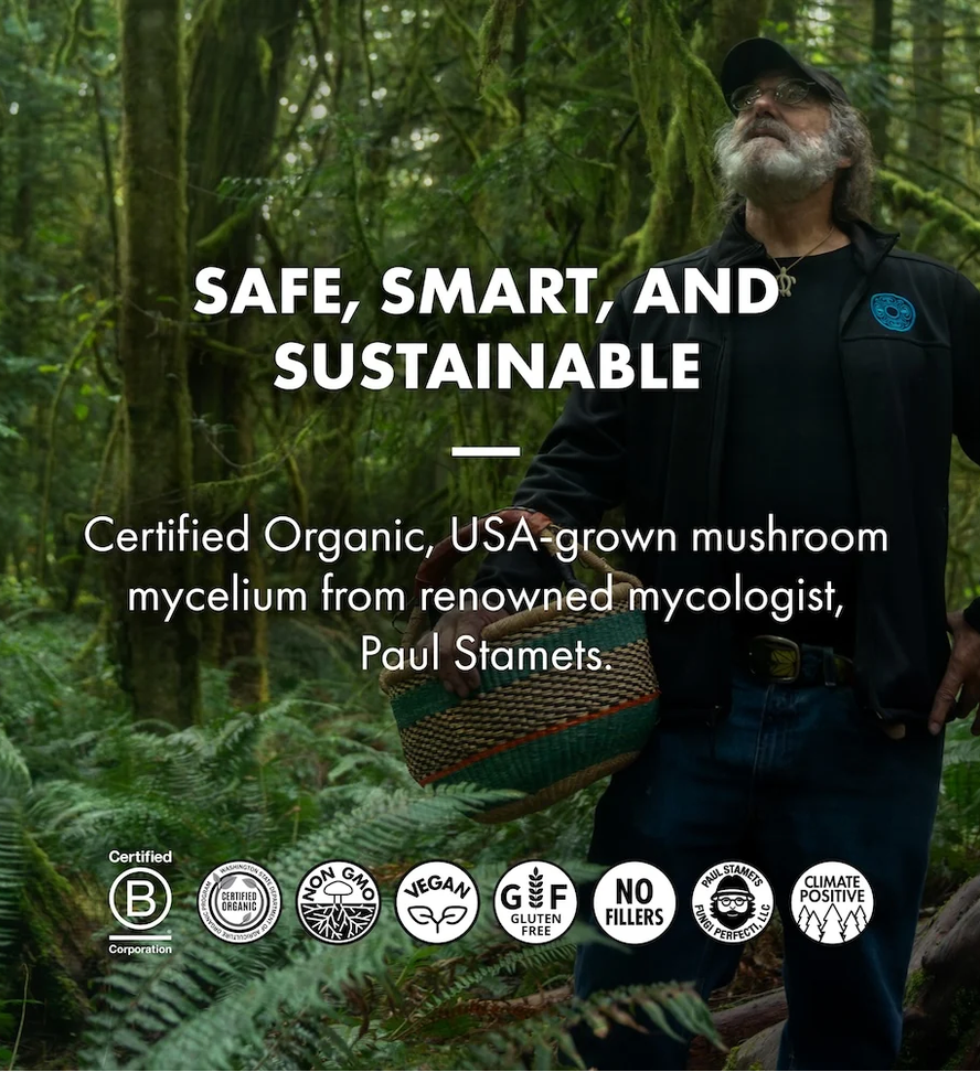 A man in a forested outdoor setting wearing a black cap and black shirt, holding a woven basket. Large white text reads 'SAFE, SMART, AND SUSTAINABLE' and 'Certified Organic, USA-grown mushroom mycelium from renowned mycologist, Paul Stamets.