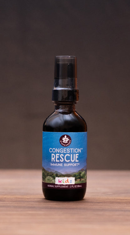 A small amber glass bottle labeled 'Concentrate Rescue' stands centered on a wooden tabletop against a dark backdrop, with blurred rustic props on both sides.
